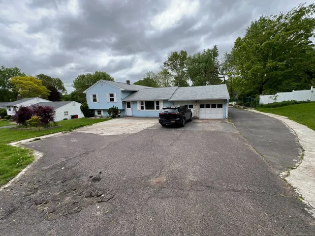 a car parked in front of a house with a yard