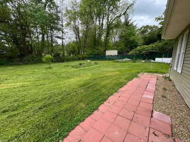 a view of yard with swimming pool and green space
