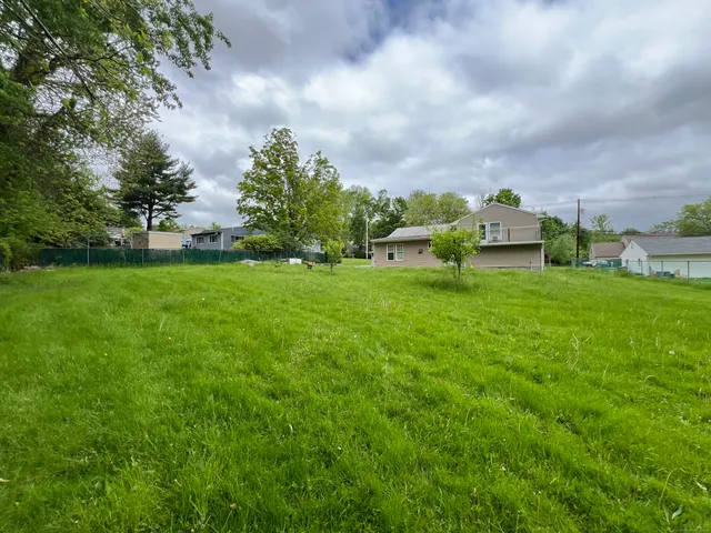 a view of a house with a big yard and sitting area