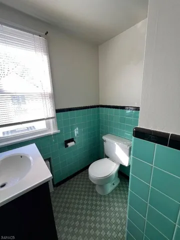 a bathroom with a toilet a sink and a mirror