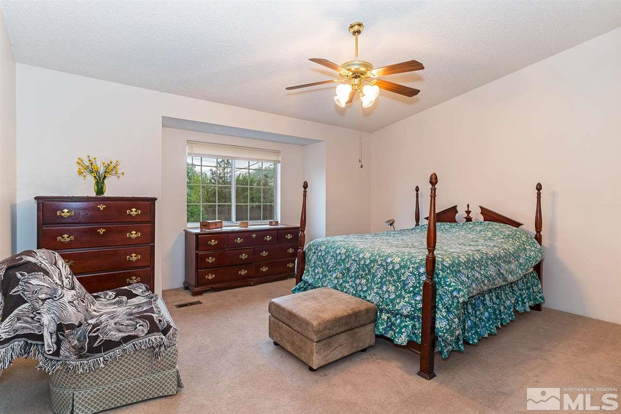 14585 Seminole Trail Reno, NV 89521 - Photo 8 of 15 a bedroom with a bed and a chandelier