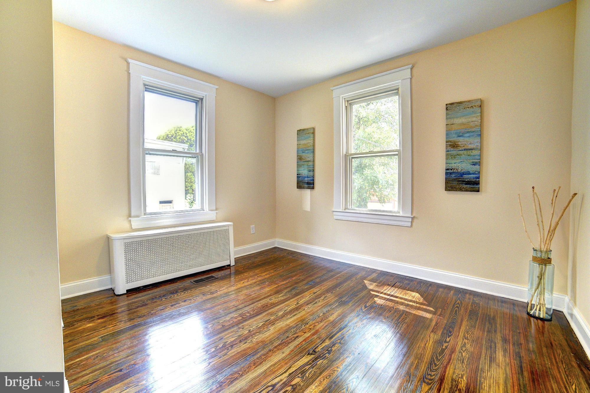 5408 Catalpha Road Baltimore, MD 21214 - Photo 12 of 23 a view of an empty room with wooden floor and a window