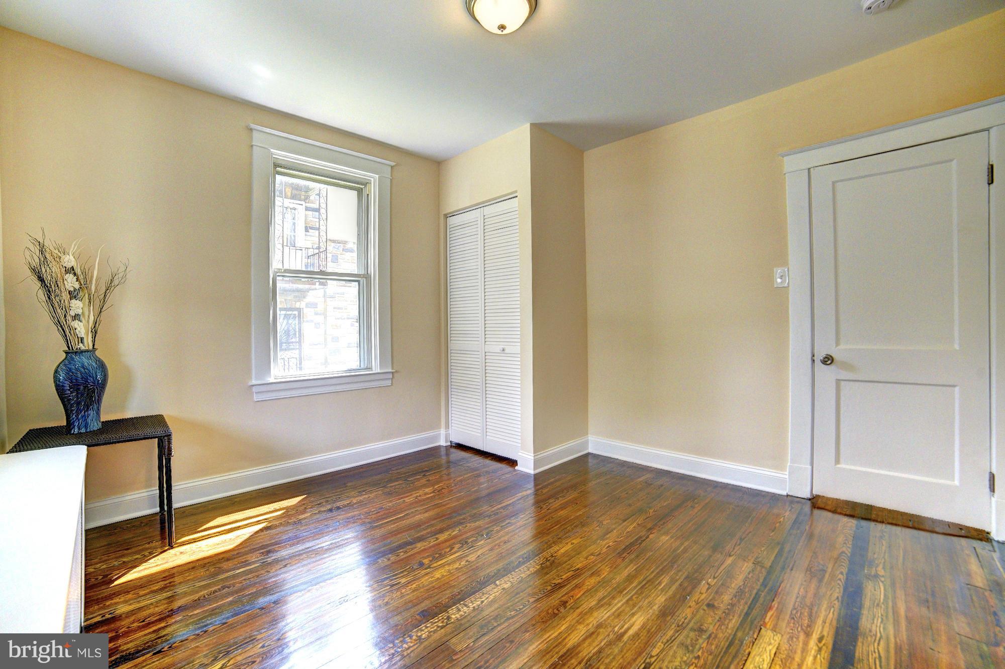 5408 Catalpha Road Baltimore, MD 21214 - Photo 13 of 23 an empty room with wooden floor and windows