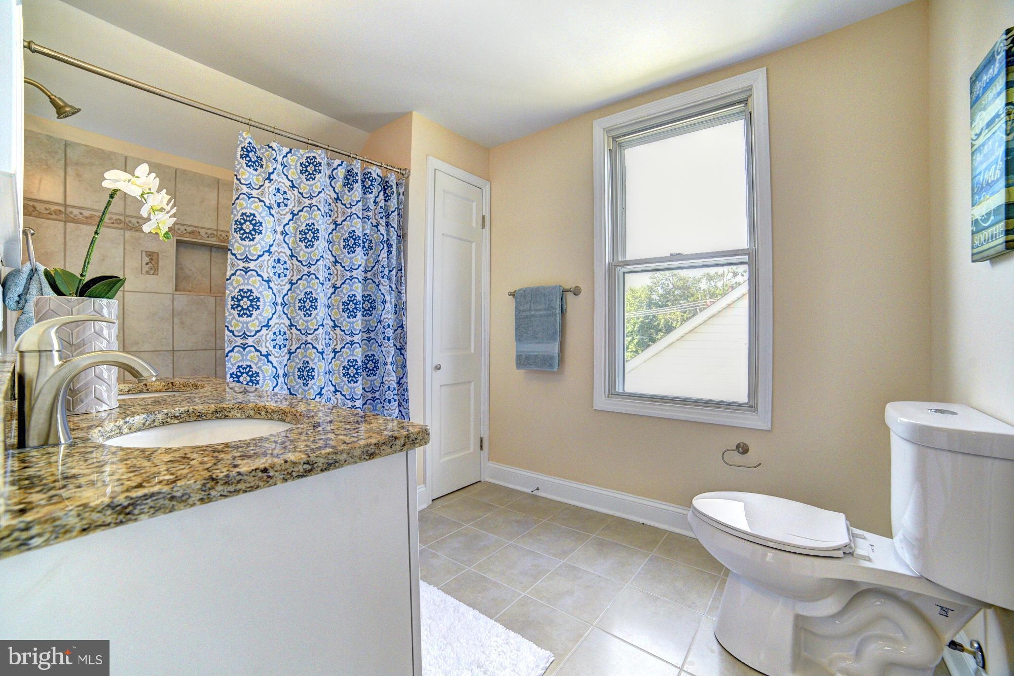 5408 Catalpha Road Baltimore, MD 21214 - Photo 16 of 23 a bathroom with a granite countertop sink toilet and shower