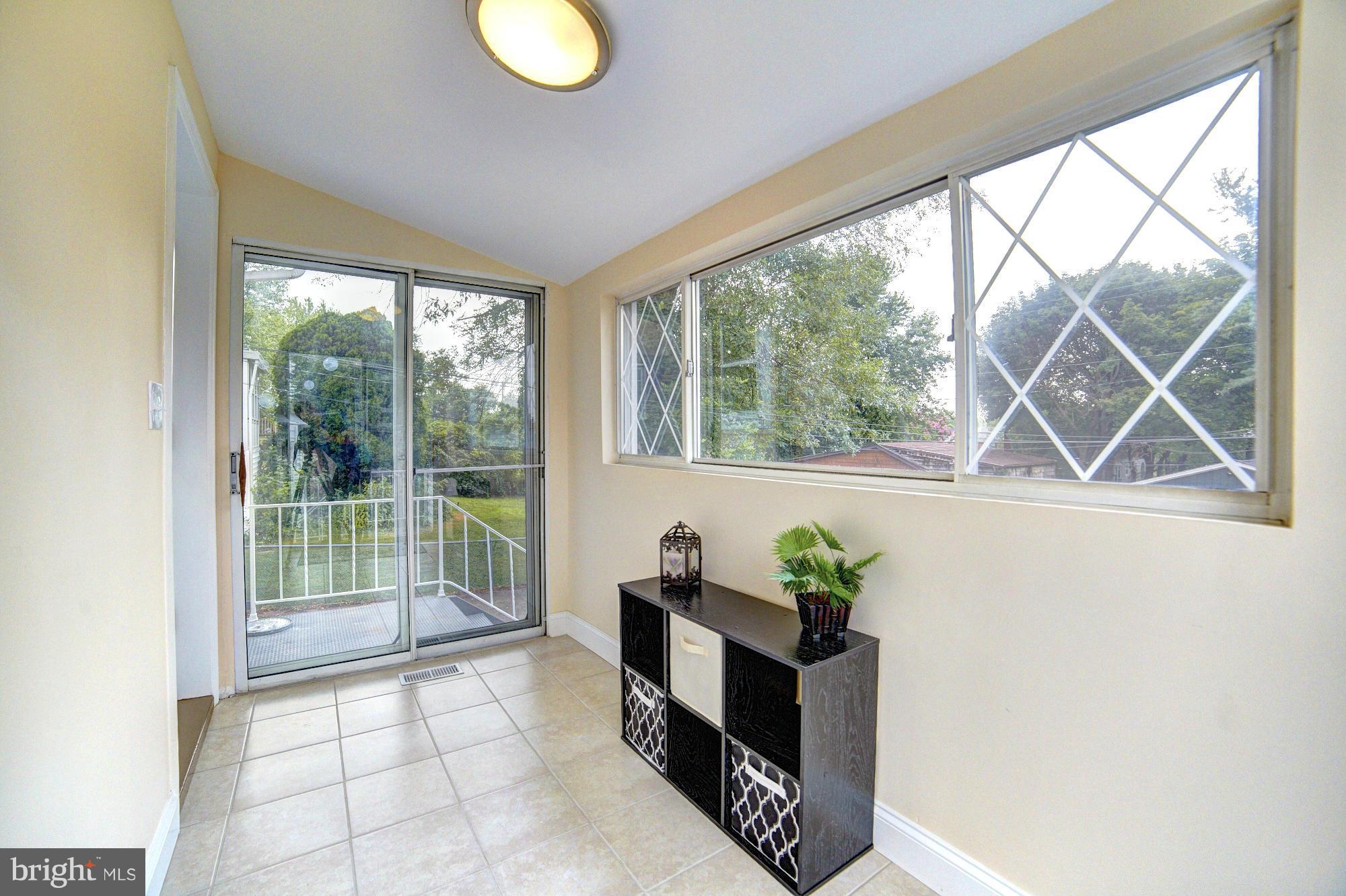 5408 Catalpha Road Baltimore, MD 21214 - Photo 21 of 23 a living room with furniture and a floor to ceiling window