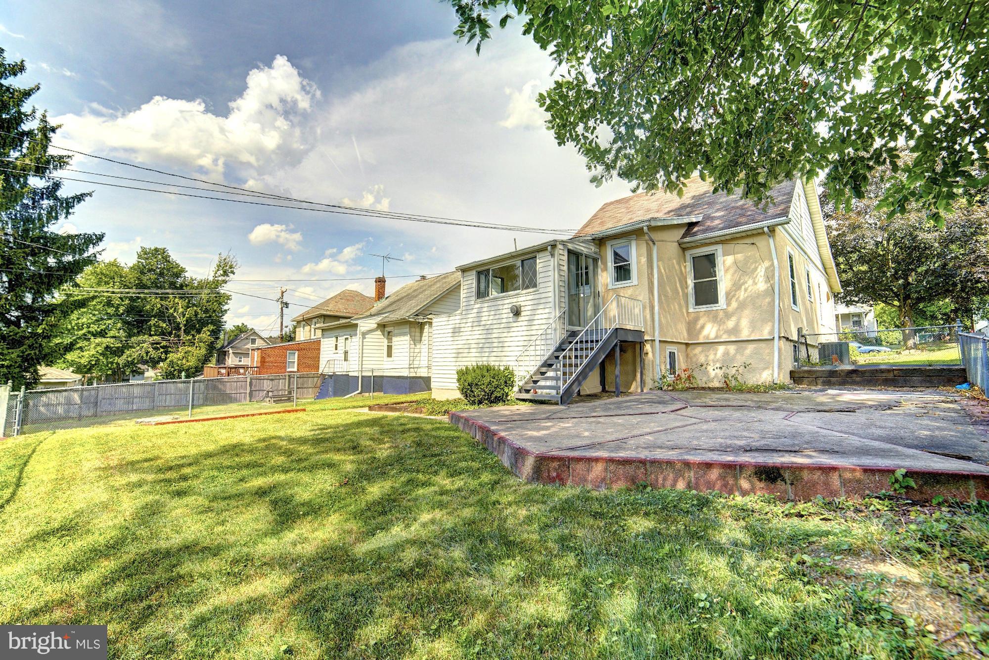 5408 Catalpha Road Baltimore, MD 21214 - Photo 22 of 23 a view of a house with a big yard and large trees