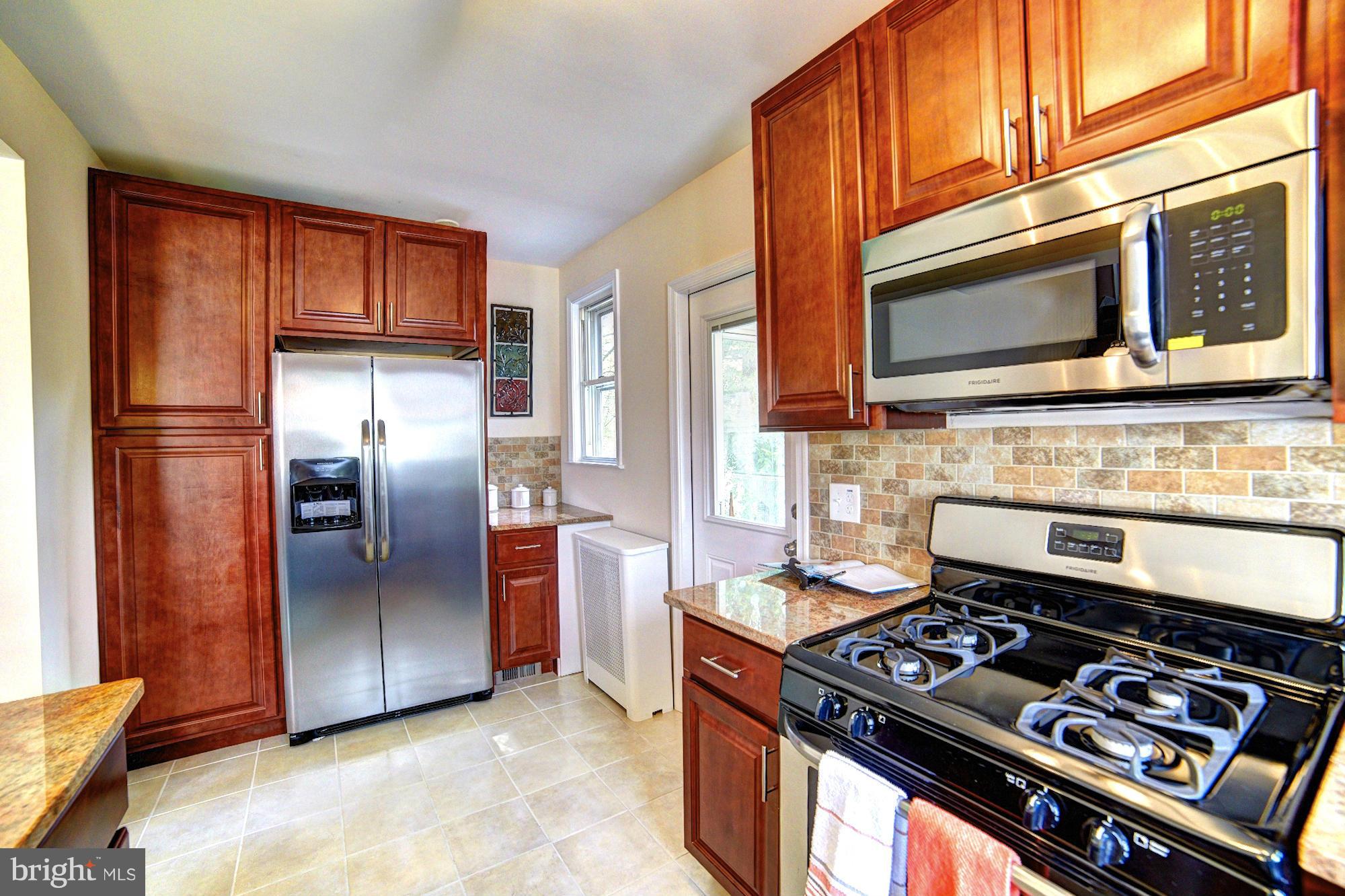 5408 Catalpha Road Baltimore, MD 21214 - Photo 10 of 23 a kitchen with stainless steel appliances granite countertop a stove microwave and refrigerator
