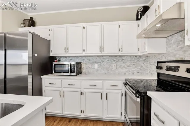 a kitchen with white cabinets and stainless steel appliances