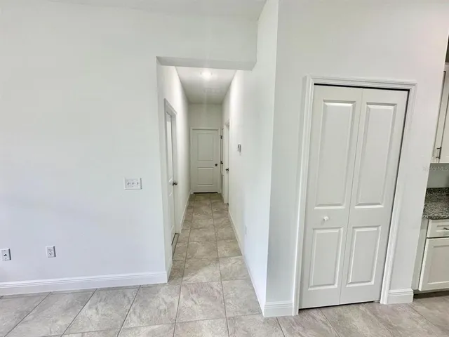 a view of a hallway with wooden floor and closet
