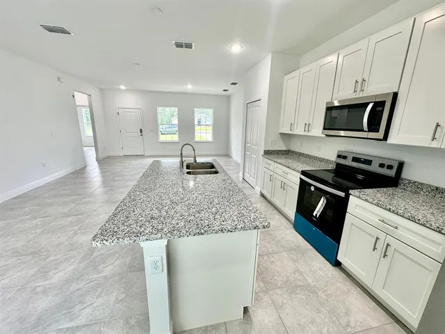 a kitchen with stainless steel appliances granite countertop a sink stove and cabinets