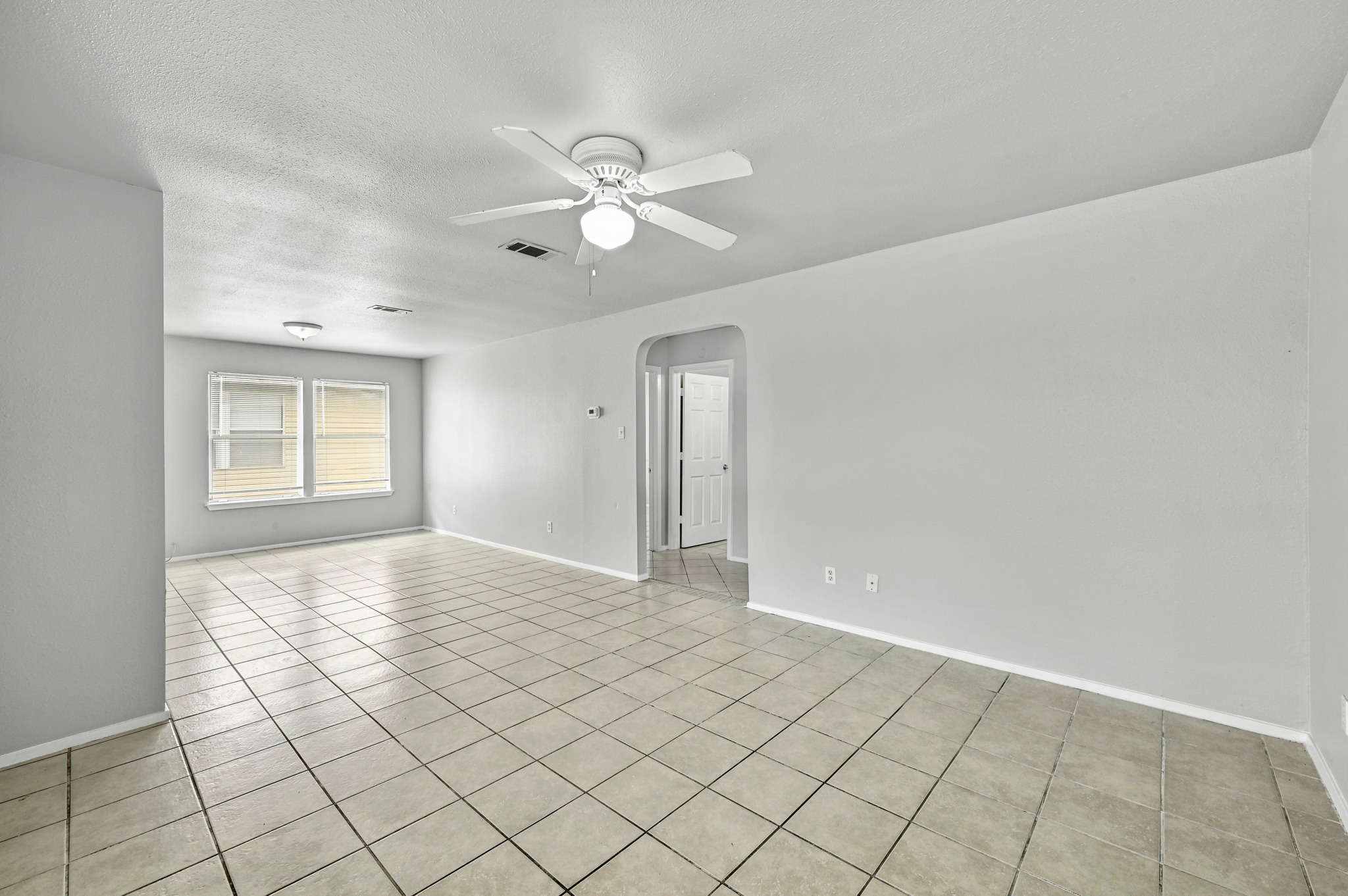 2212 Katy Lane Georgetown, TX 78626 - Photo 7 of 27 Spacious room featuring tile flooring, a ceiling fan with integrated lighting, and windows providing natural light