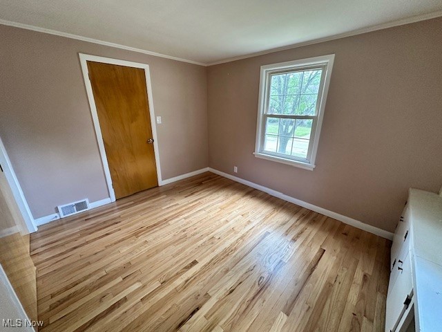 15959 Glynn Road Cleveland, OH 44112 - Photo 21 of 23 Unfurnished bedroom featuring a closet, ornamental molding, and light wood-style flooring
