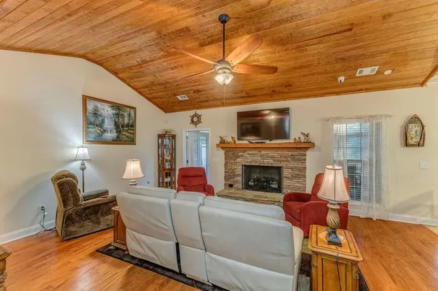 a kitchen with stainless steel appliances granite countertop a stove top oven a sink dishwasher and a refrigerator with wooden cabinets