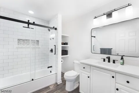 a bathroom with a sink mirror toilet and shower