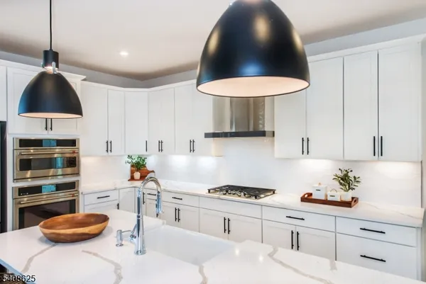 a kitchen with stainless steel appliances a sink a stove and a wooden floor