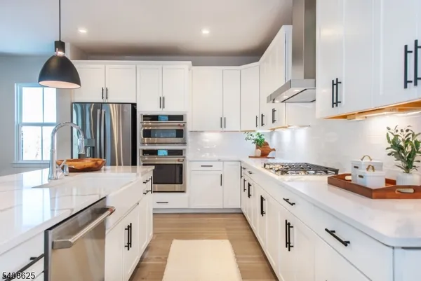 a kitchen with stainless steel appliances a stove a sink and a refrigerator