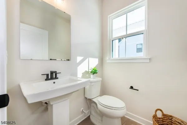 a bathroom with a sink a toilet and a window