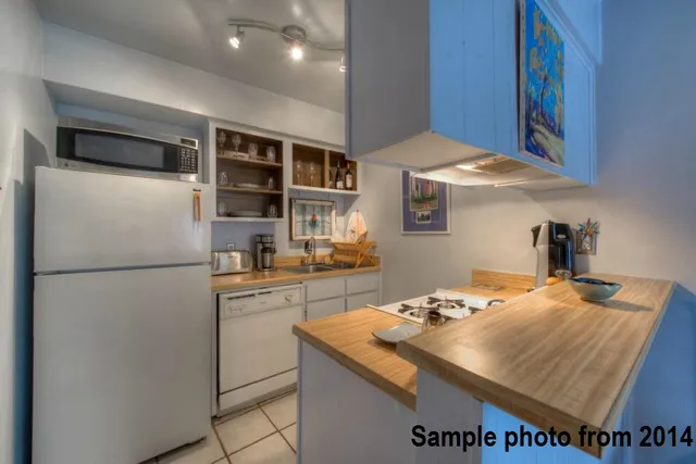 a kitchen with stainless steel appliances granite countertop a refrigerator a sink and a stove