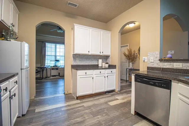 a kitchen with a refrigerator and a stove top oven