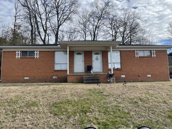 a view of a house with a yard and a tree