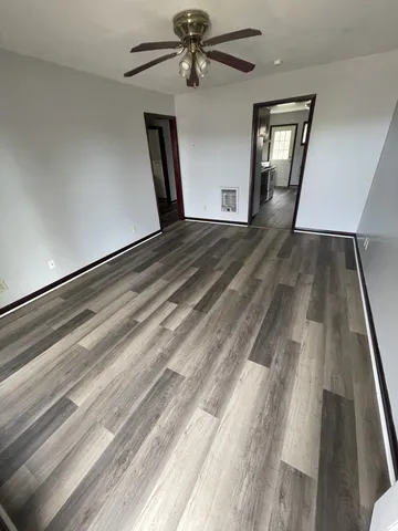 a view of empty room with wooden floor