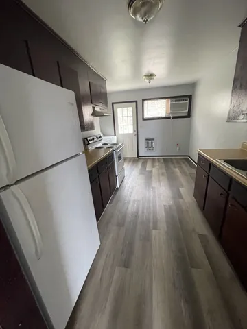 a view of a kitchen with wooden floor and electronic appliances