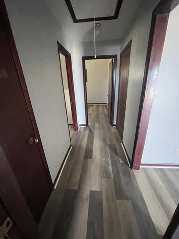 a view of a hallway with wooden floor and staircase