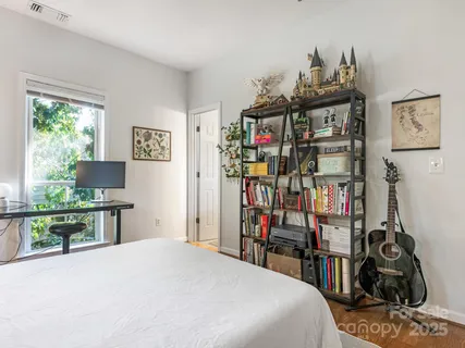 a bedroom with a bed a book shelf and a window
