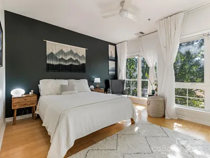 a bedroom with a bed and a large window