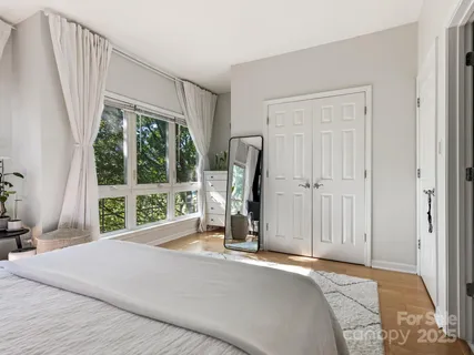 a bedroom with a bed a table and a large window