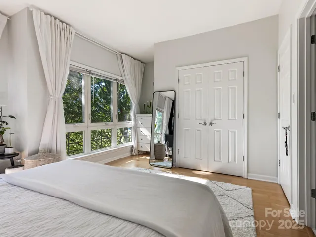 a bedroom with a bed a table and a large window