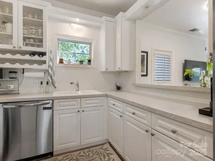 a kitchen with white cabinets and a window