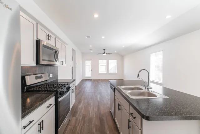a kitchen that has a sink a stove and window