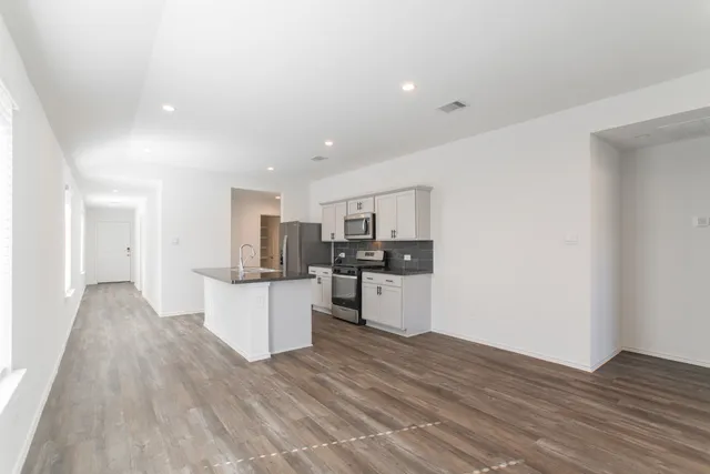 a view of kitchen with wooden floor and electronic appliances