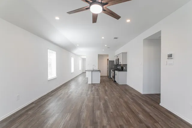 a view of empty room with wooden floor and window