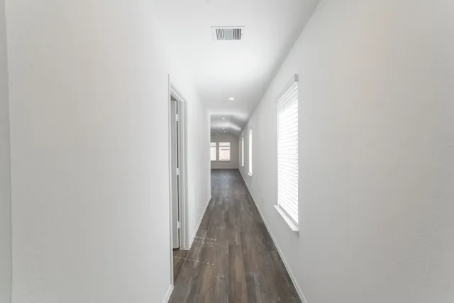 a view of a hallway with wooden floor