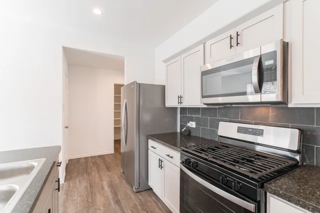 a kitchen with stainless steel appliances granite countertop a stove and a refrigerator