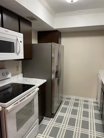 a kitchen with a sink a refrigerator and cabinets