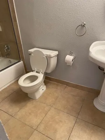 a white toilet sitting next to a bathroom sink