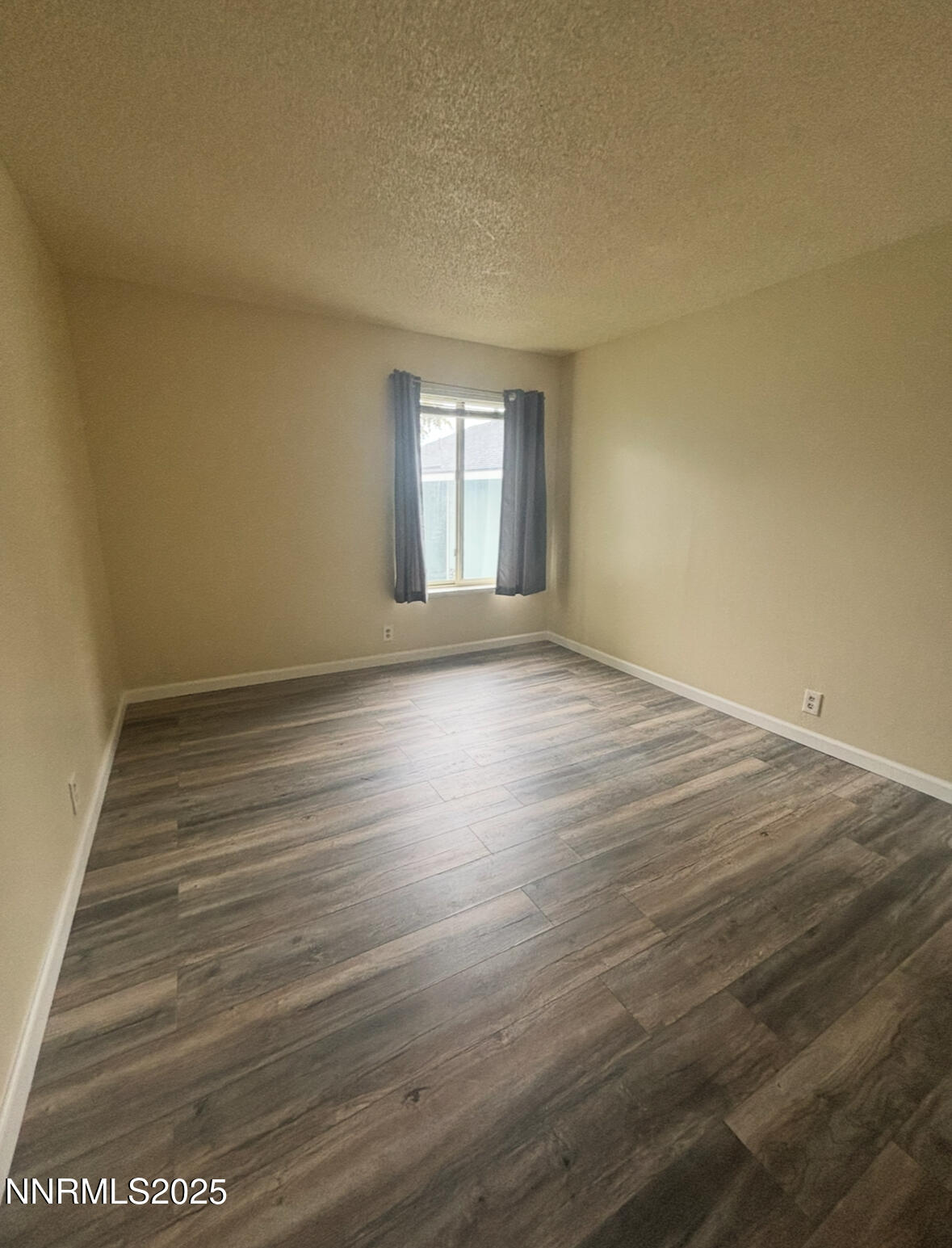 4604 Neil Road, Unit 114 Reno, NV 89502 - Photo 12 of 15 a view of an empty room with wooden floor and a window