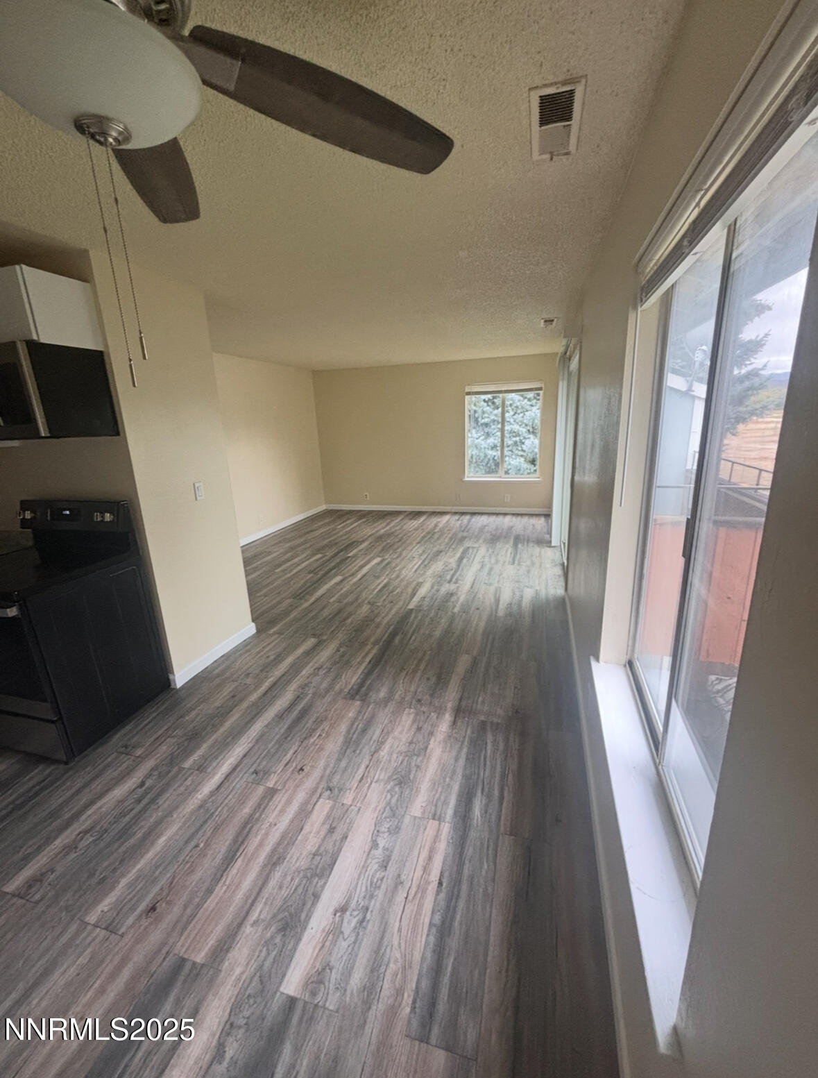 4604 Neil Road, Unit 114 Reno, NV 89502 - Photo 4 of 15 a view of an empty room with wooden floor and a window