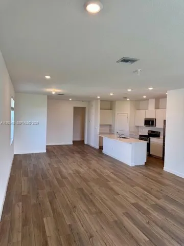 a view of kitchen with kitchen island wooden floor and center island
