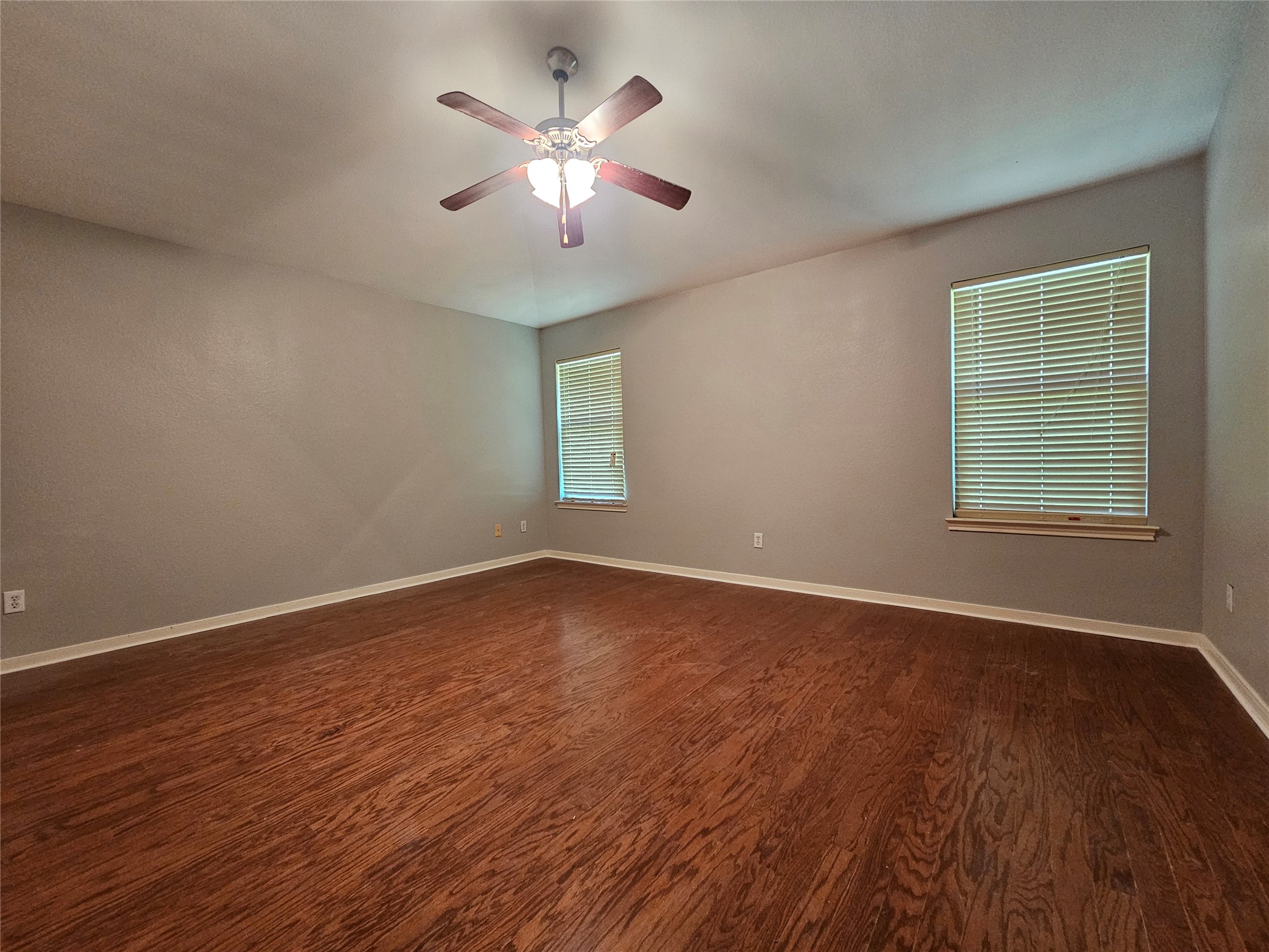 2035 Intrepid Drive Buda, TX 78610 - Photo 12 of 26 Wood flooring and natural light elevate this inviting bedroom.