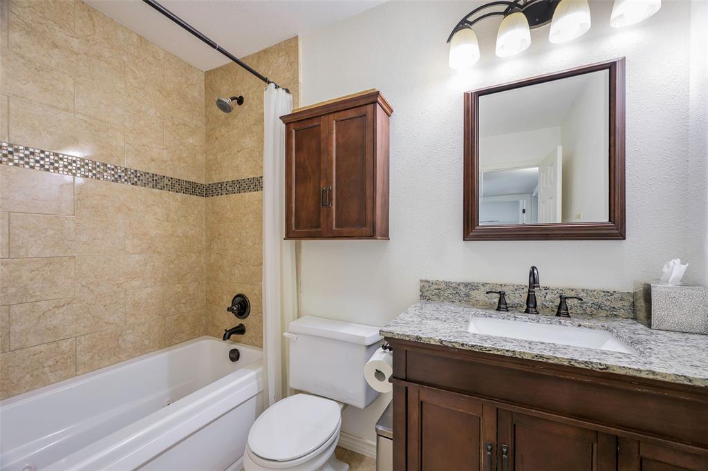 5810 Galaxie Road Garland, TX 75044 - Photo 19 of 33 a bathroom with a granite countertop sink mirror toilet and bathtub