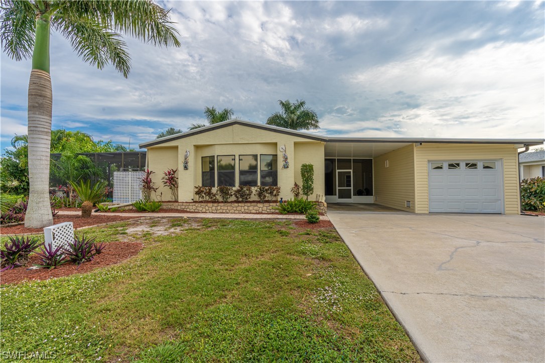 109 Audubon Road Naples, FL 34114 - Photo 1 of 41 a front view of a house with garden