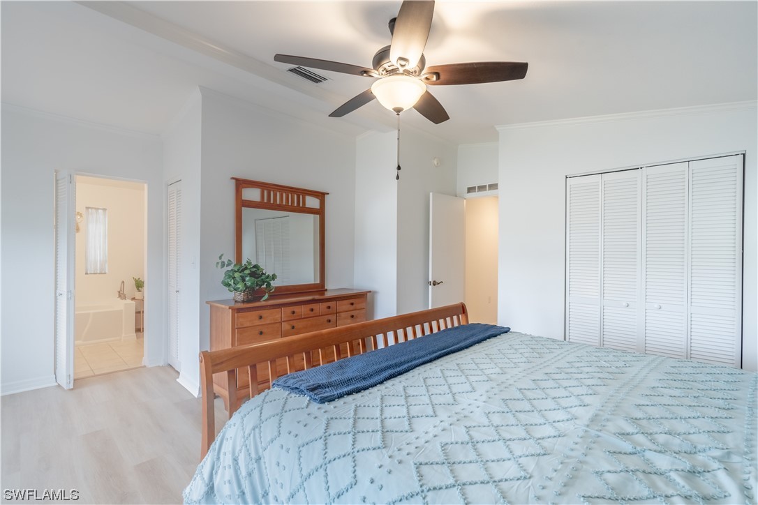 109 Audubon Road Naples, FL 34114 - Photo 21 of 41 a bedroom with a large bed and a chandelier fan
