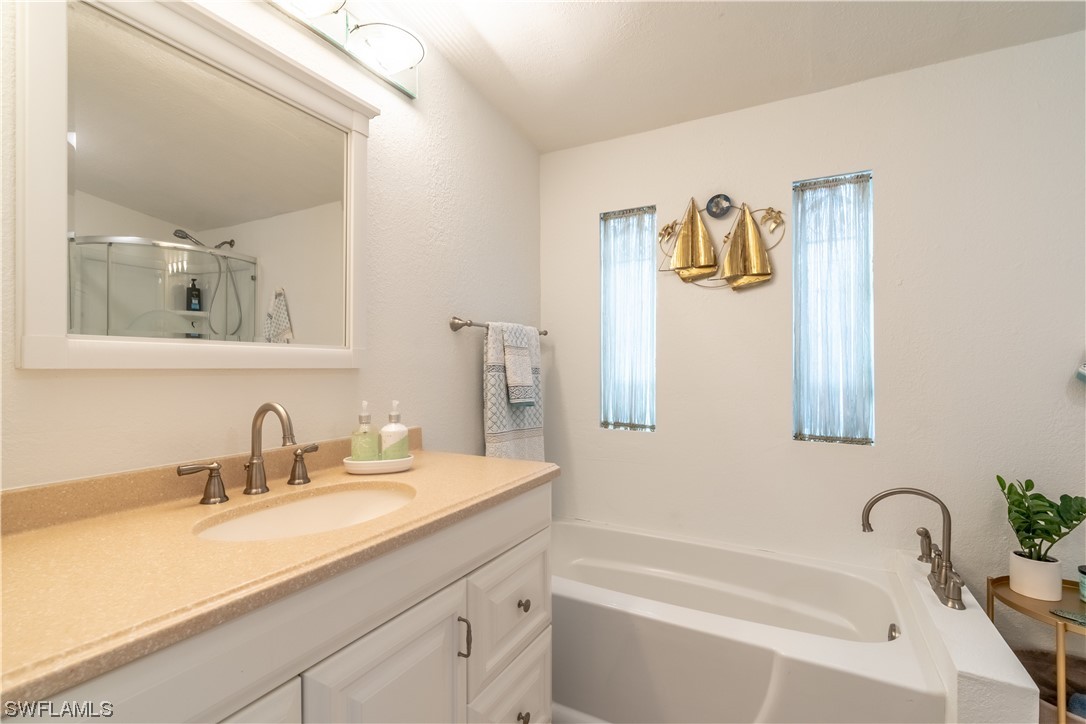 109 Audubon Road Naples, FL 34114 - Photo 24 of 41 a bathroom with a tub sink and mirror