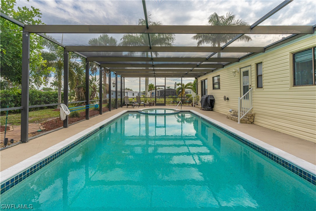 109 Audubon Road Naples, FL 34114 - Photo 27 of 41 a swimming pool with a garden view