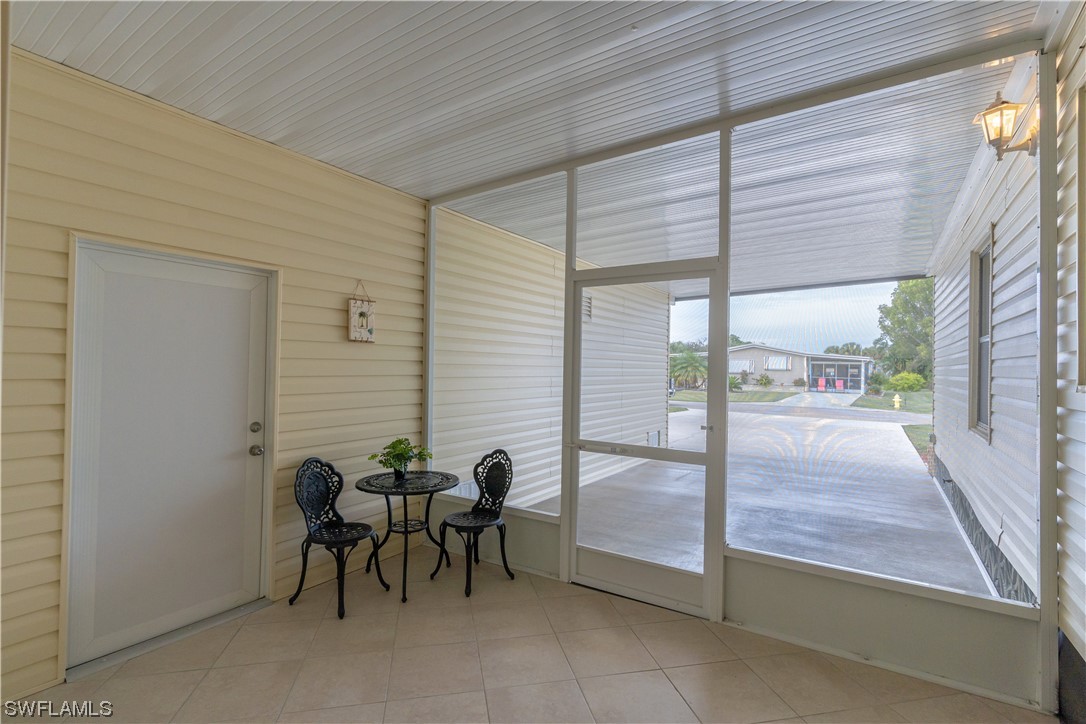 109 Audubon Road Naples, FL 34114 - Photo 3 of 41 a view of a patio with table and chairs and floor to ceiling window