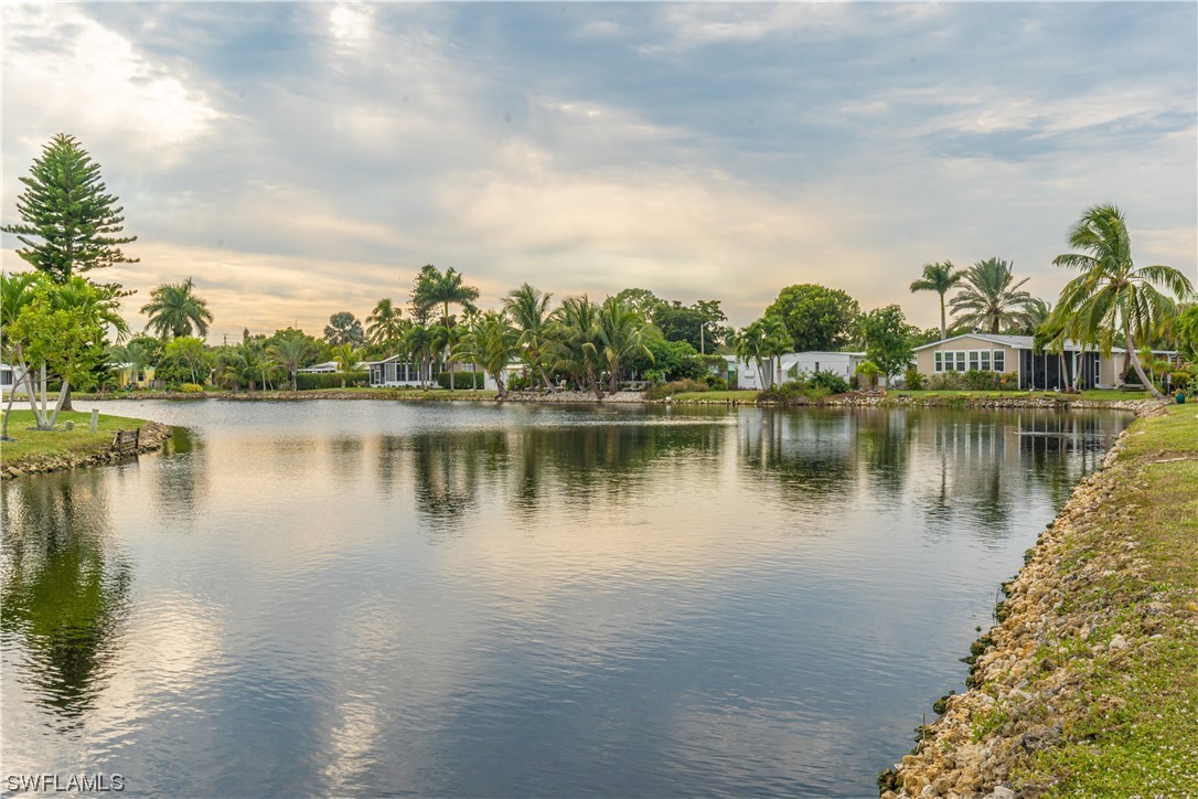 109 Audubon Road Naples, FL 34114 - Photo 31 of 41 a view of a lake with houses in the back